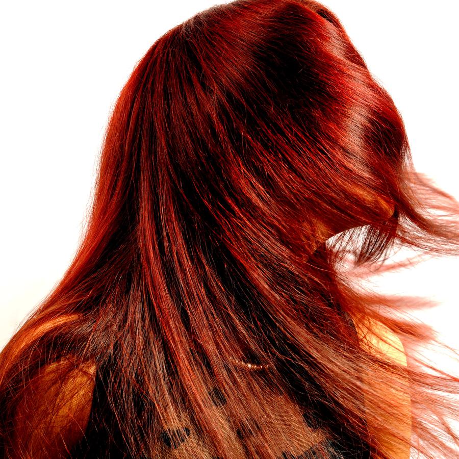 Woman with long red hair sweeping across her face.